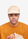 Model wearing the Imaan Vouge 5-Panel Noble Hat in nude velvet with pearl trim