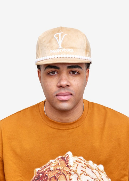 Model wearing the Imaan Vouge 5-Panel Noble Hat in nude velvet with pearl trim